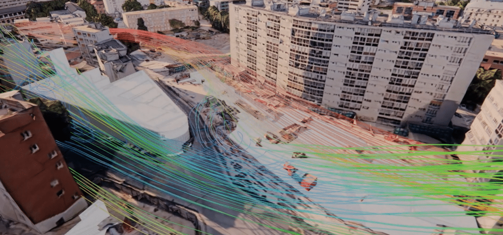 Simulación CFD: líneas de corrientes de aire superpuestas en una vista aérea externa del sitio de construcción de la estación RER de Issy, con edificios residenciales circundantes.